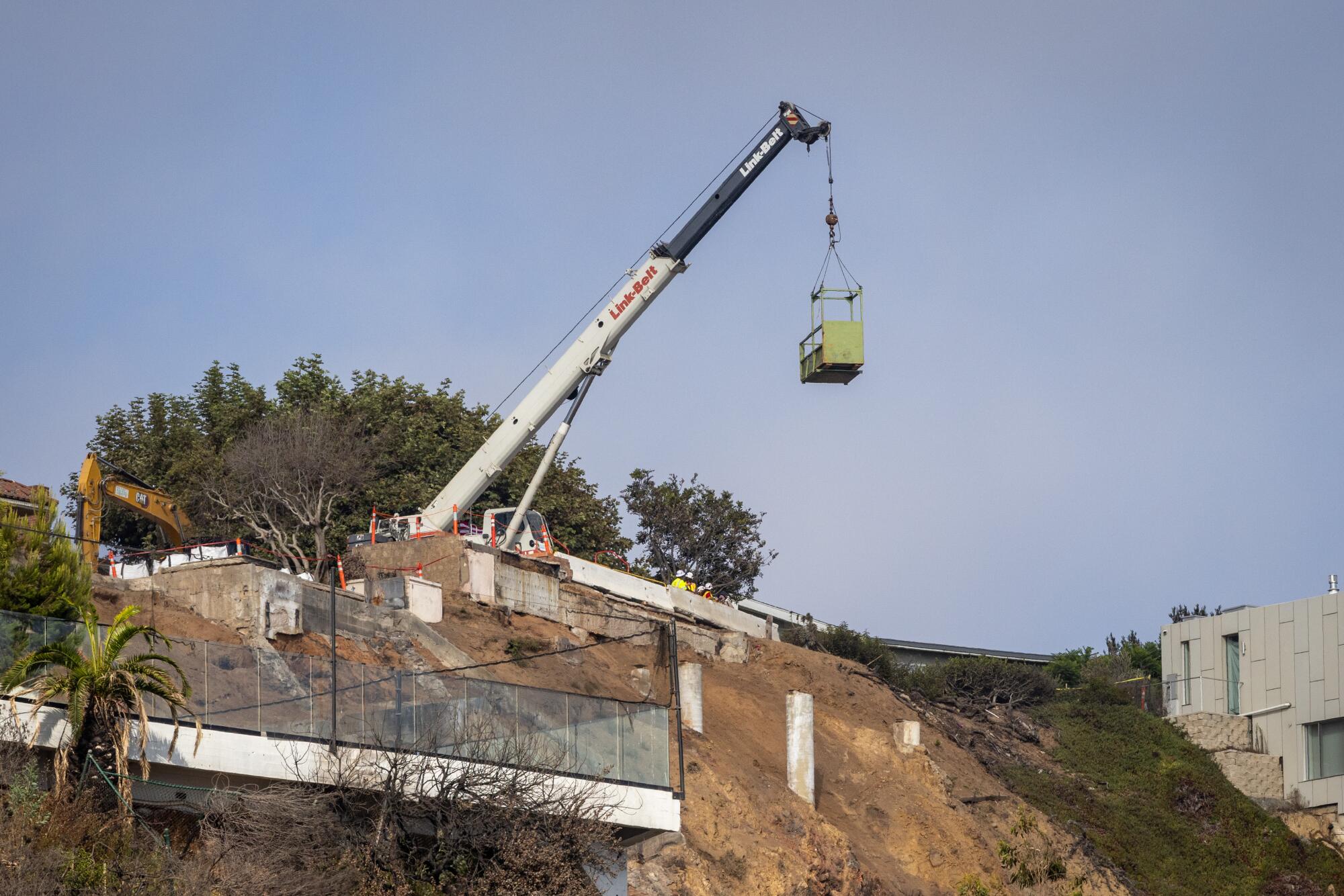A construction crane on top of a hillside.
