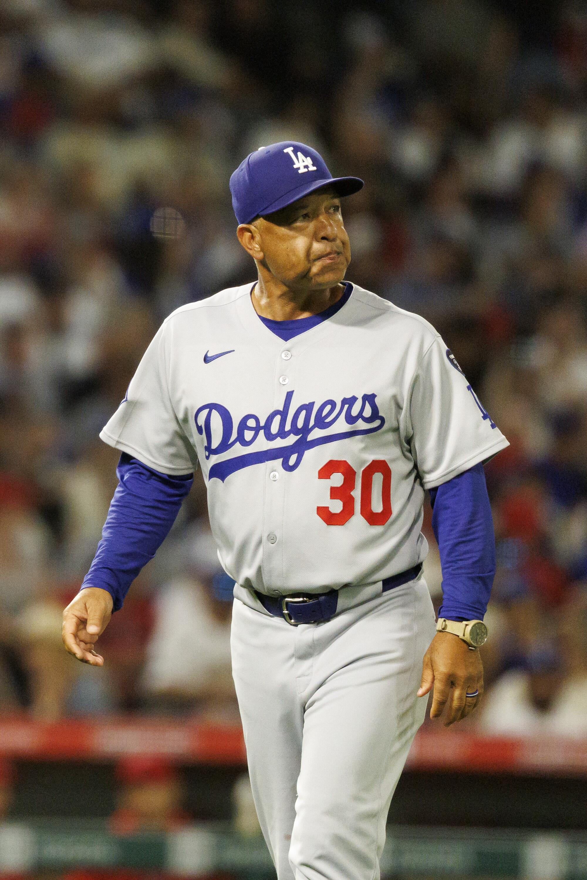 Dodgers manager Dave Roberts walks off the field after pulling Yoshinobu Yamamoto from the game.