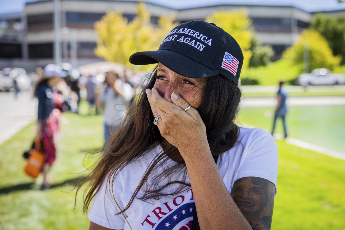 A woman covers her mouth with one hand.
