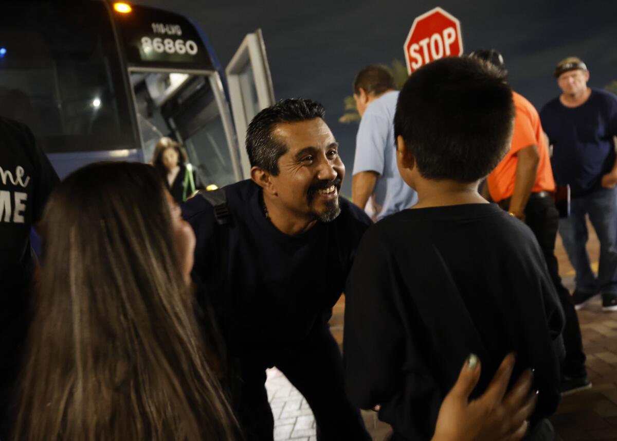 Angel Rodrigo Minguela Palacios greets his son and wife after arriving at Union Station in a Greyhound bus from Phoenix