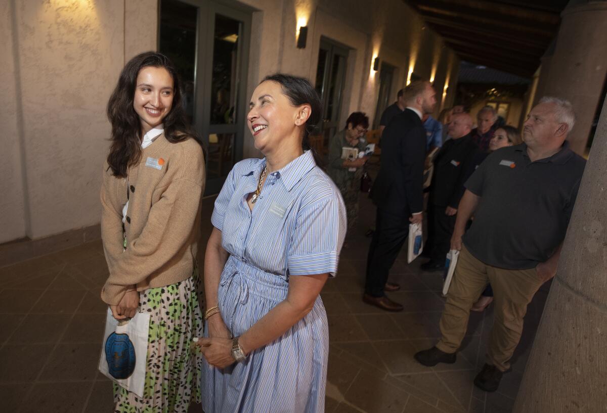 Two women smile together.