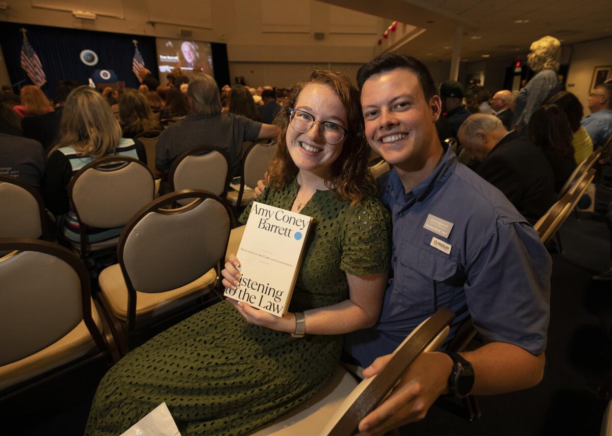 A couple holds a copy of Amy Coney Barrett's book.