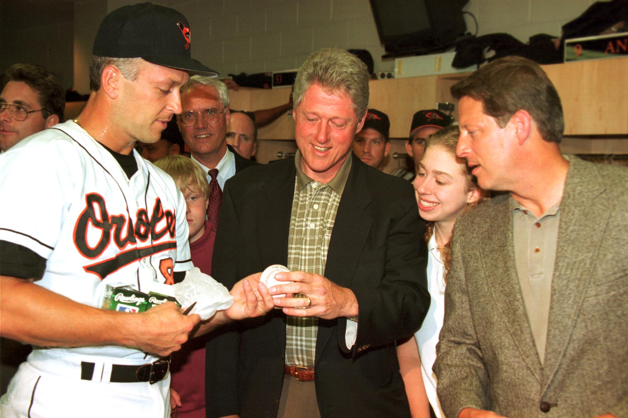 President Bill Clinton is handed an autographed ball by Baltimore Orioles shortstop Cal Ripken Jr.