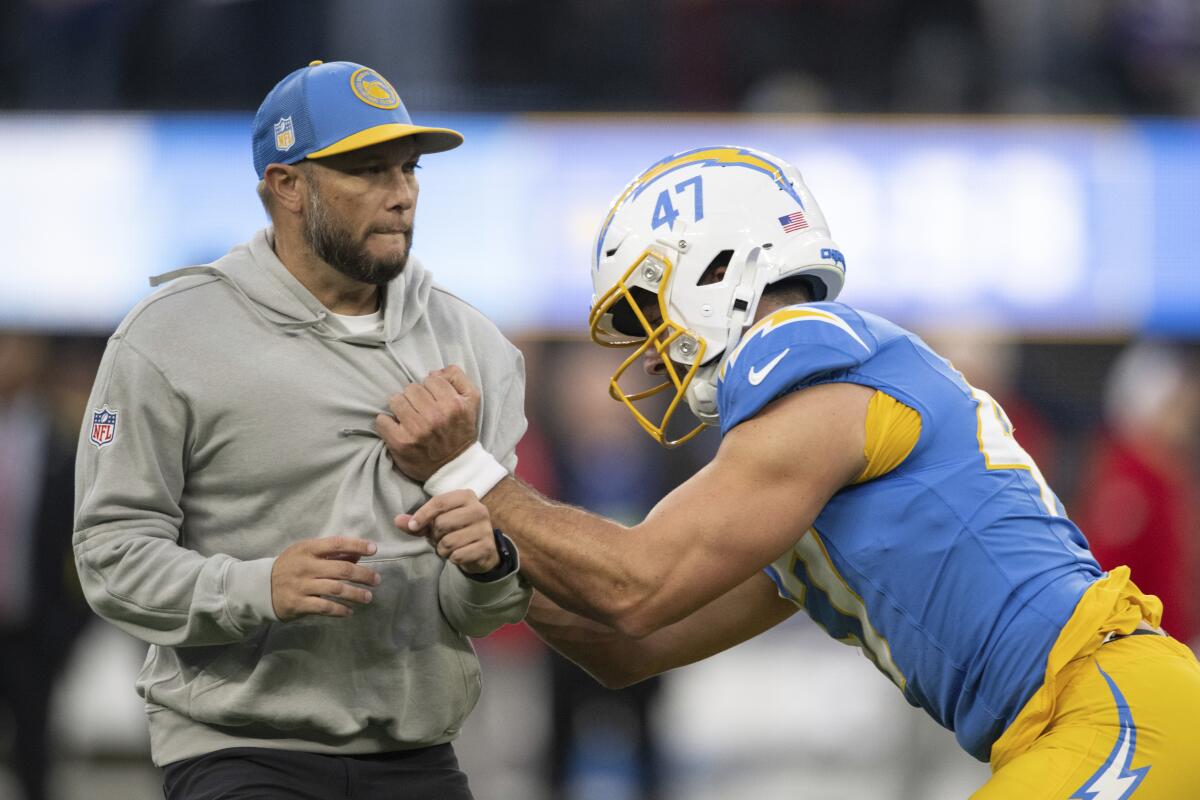 Chargers special teams coordinator Ryan Ficken, left, works with long snapper Josh Harris before a game.