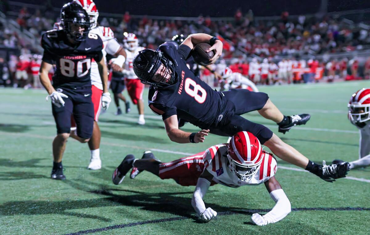 Corona Centennial quarterback Dominick Catalano flies through the air while getting tackled.