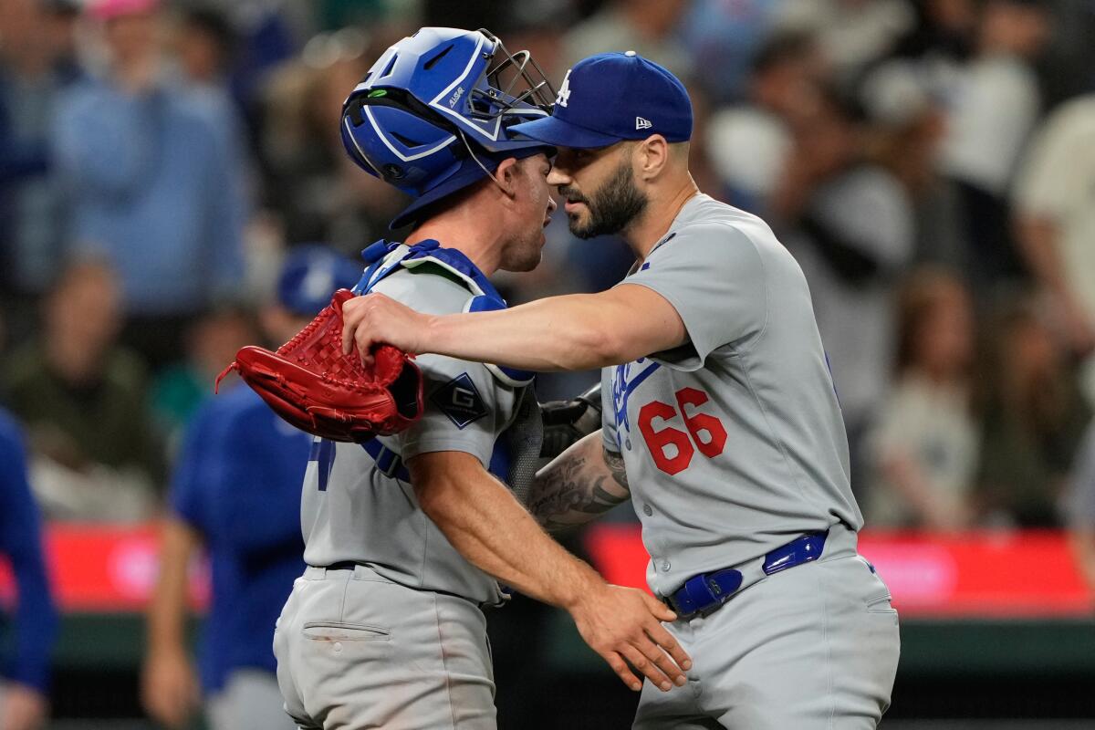 Dodgers reliever Tanner Scott, right, celebrates with catcher Ben Rortvedt after the team's 3-2 win over the Mariners.