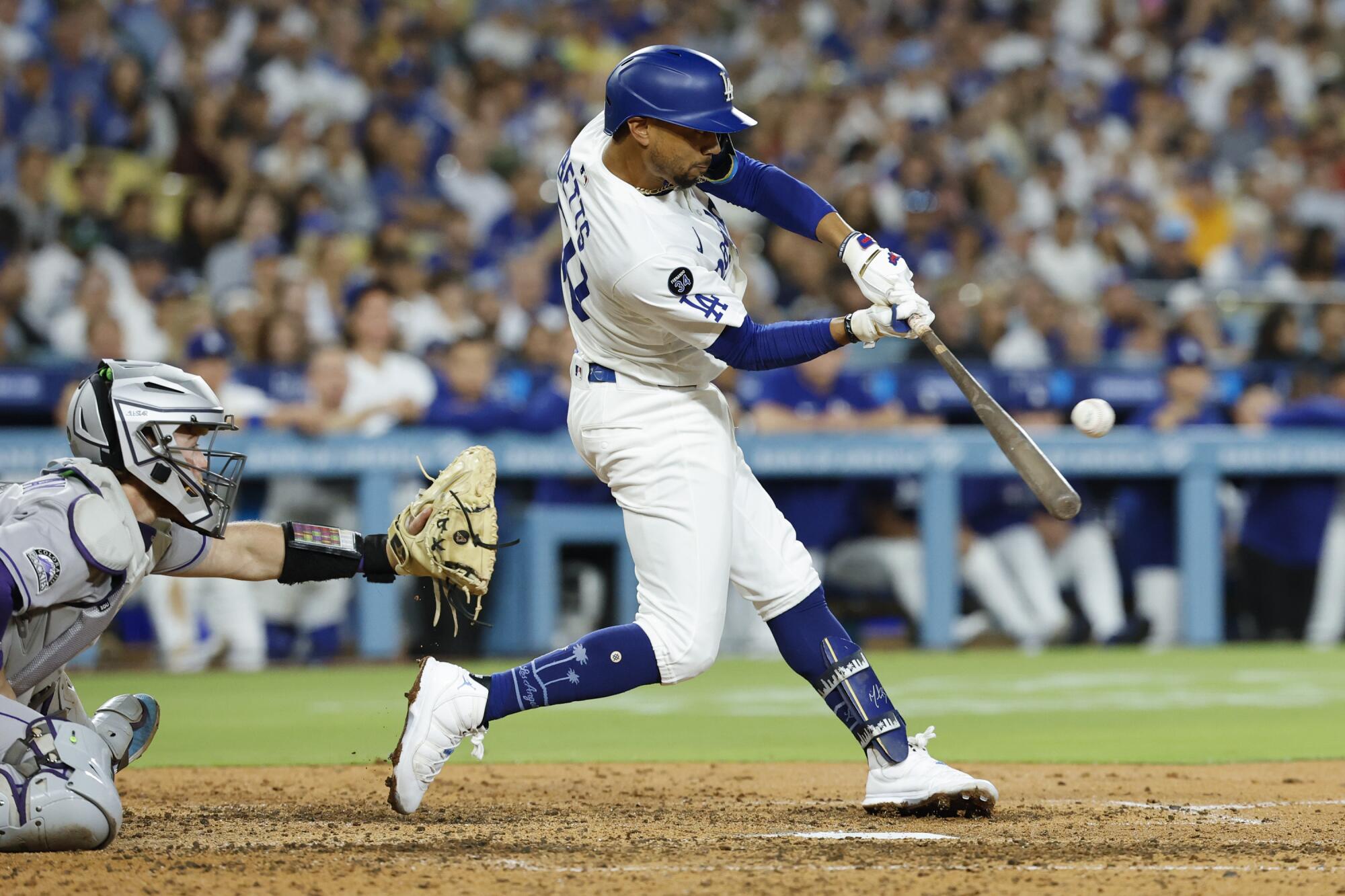 Mookie Betts hits a two-run single in the seventh inning during the Dodgers' 3-1 win over the Rockies on Monday.