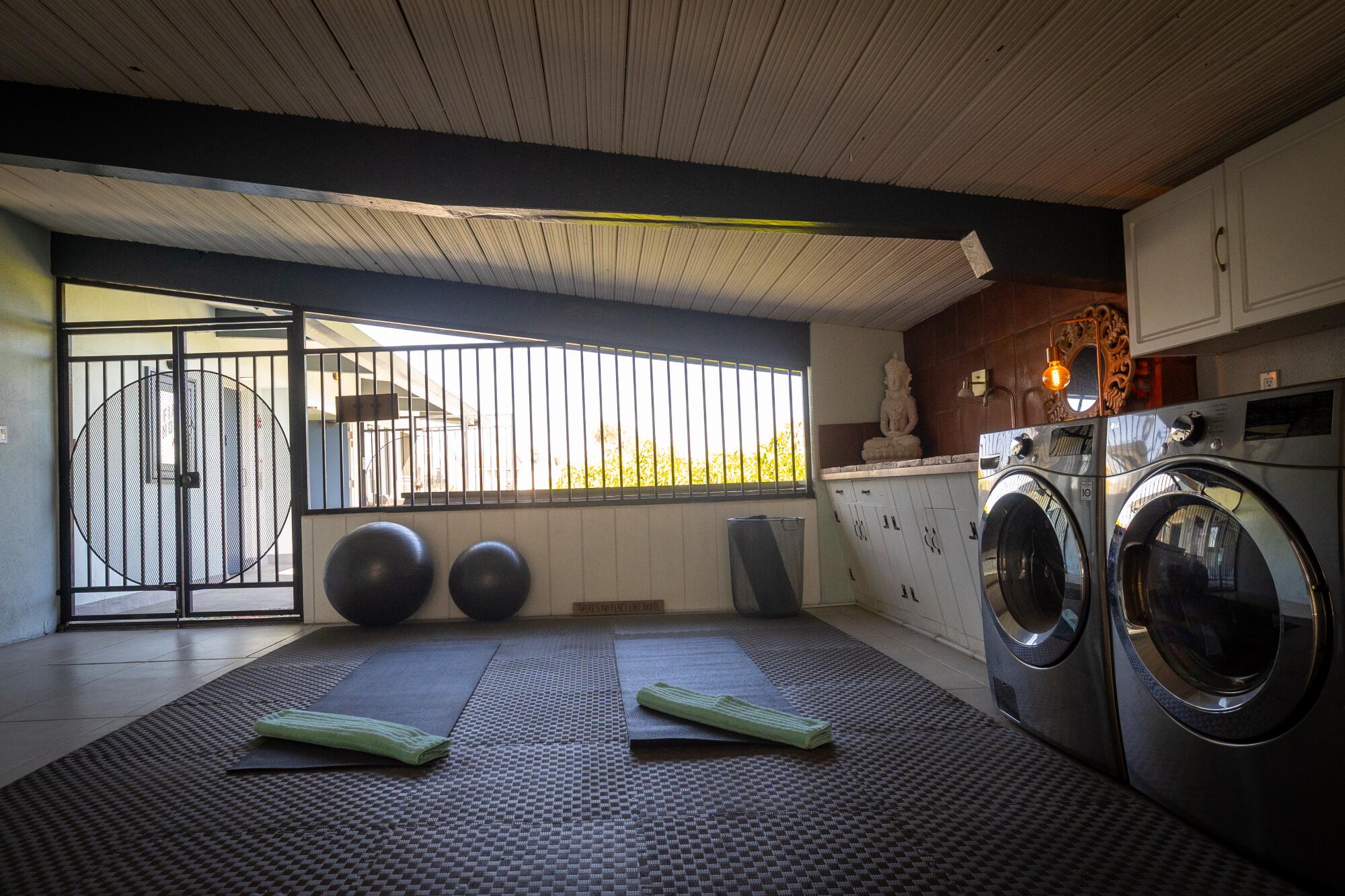 A lanai area with mats, weights and washer and dryer.