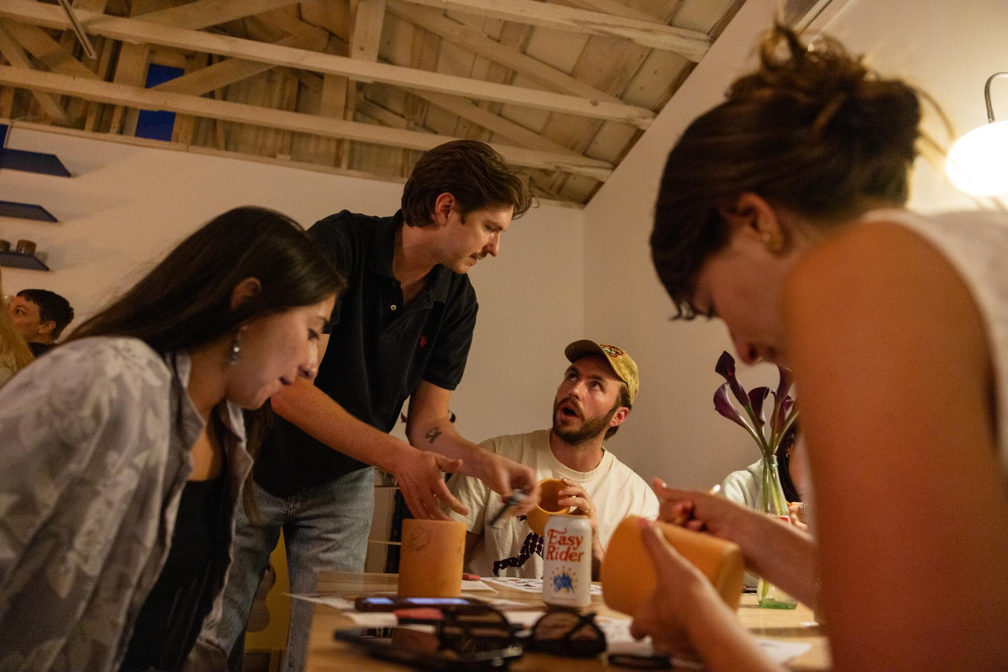 Steve Stringer, center, instructs an event participant during his Tattoo a Mug workshop.