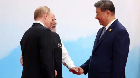 Reuters Russian President Vladimir Putin, Indian Prime Minister Narendra Modi and Chinese President Xi Jinping speak during a meeting at the Shanghai Cooperation Organisation (SCO) summit in Tianjin, China on 1 September, 2025. 