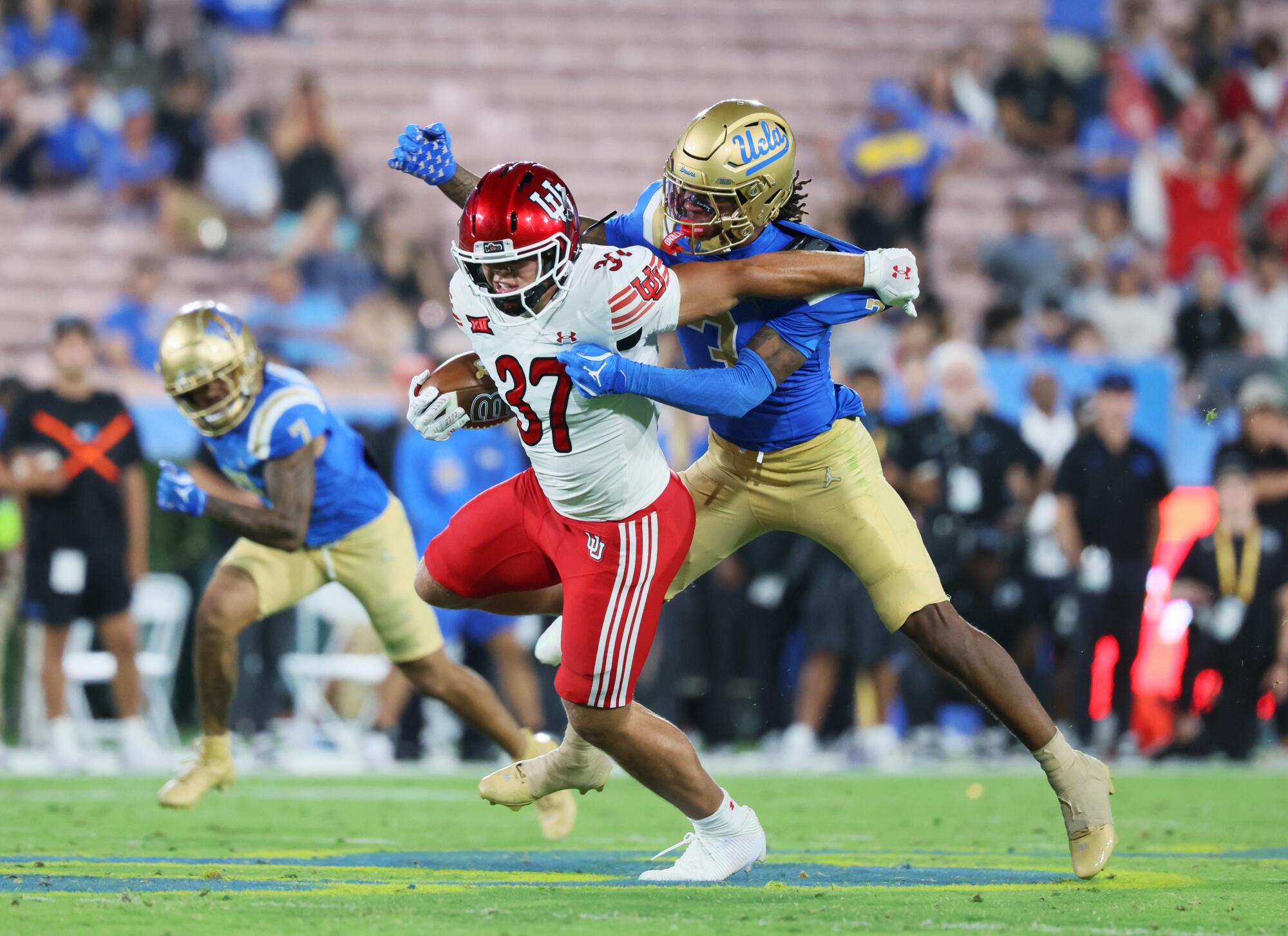 Utah linebacker Trey Reynolds (37) intercepts the ball as UCLA receiver Kwazi Gilmer (3) tries to stop him on Aug. 31.