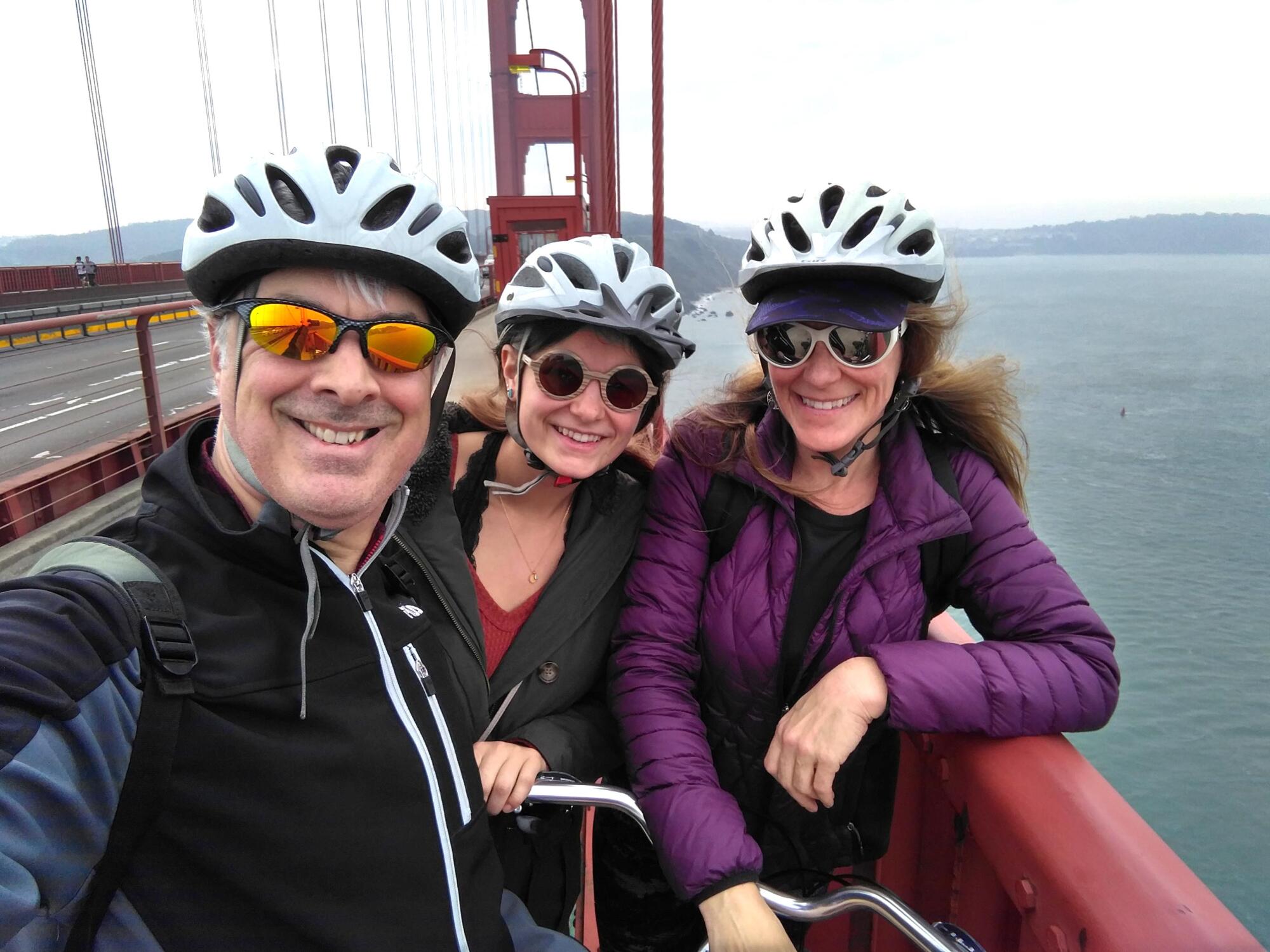 Marc, Julia (right), and their daughter take a selfie on the Golden Gate Bridge during a bike ride.