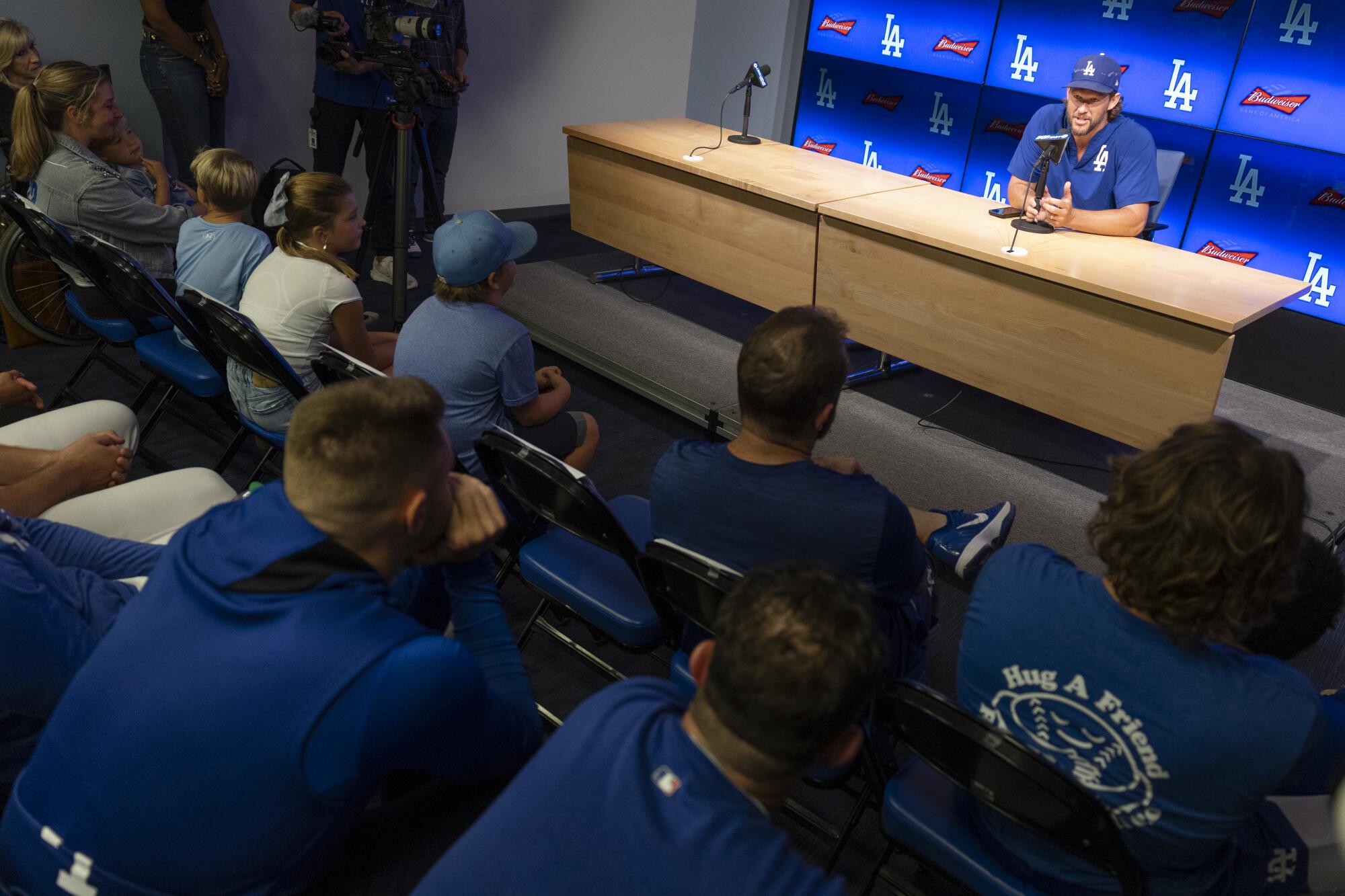 Clayton Kershaw's family and Dodgers players listen to Kershaw speak during his retirement news conference.