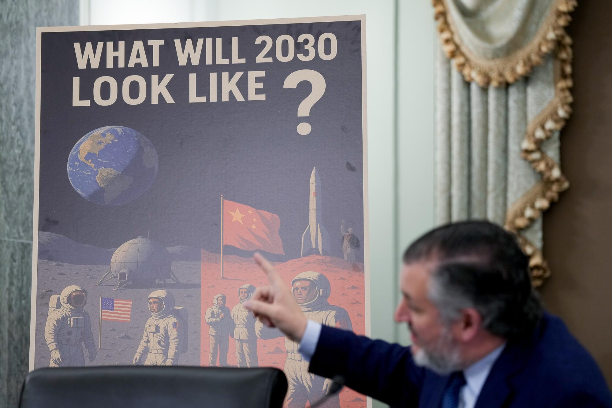 A "What Will 2030 Look Like?" sign behind Sen. Ted Cruz with American and Chinese astronauts on the moon