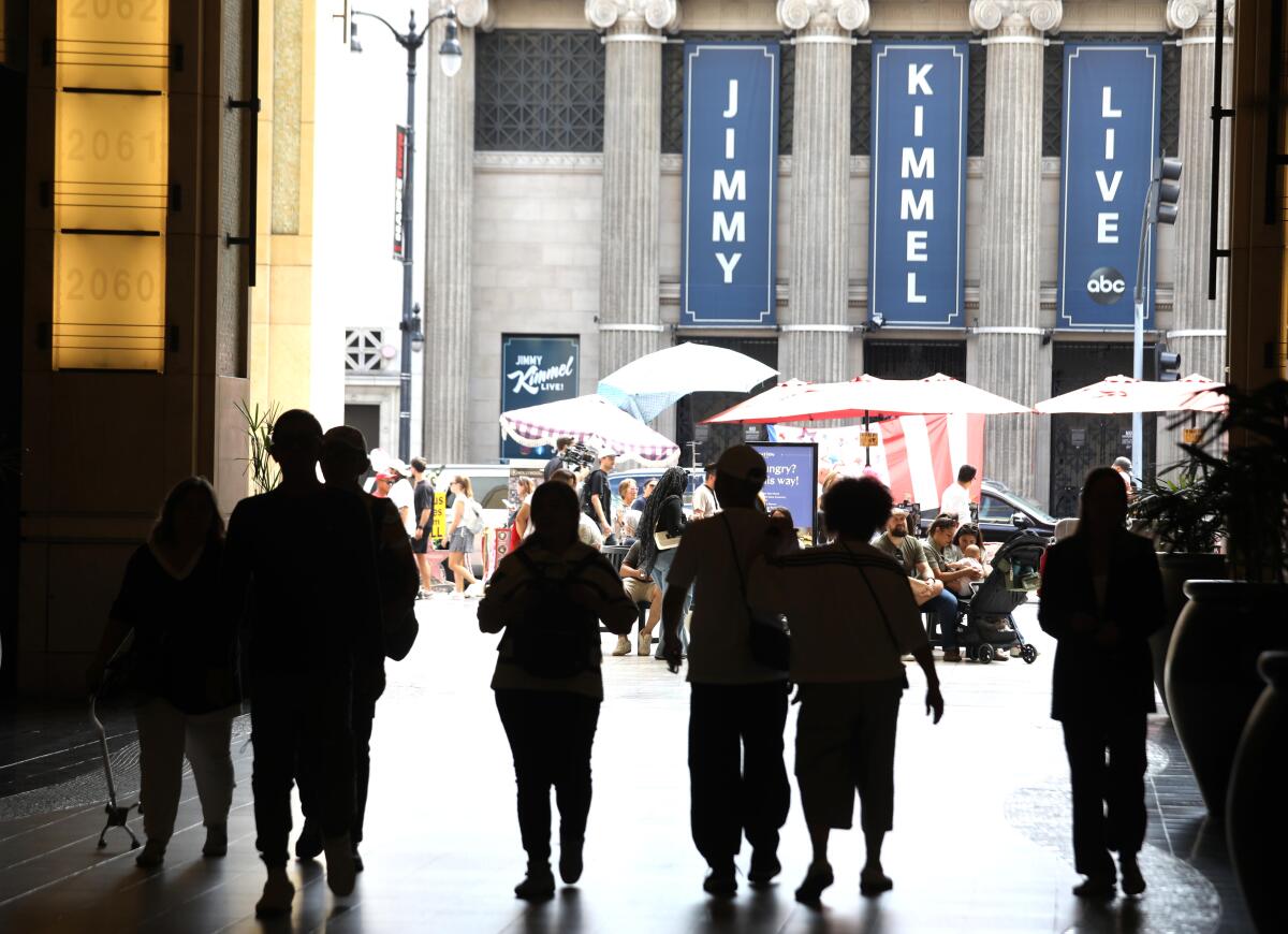 Pedestrians walk across the street from the Jimmy Kimmel Theater.