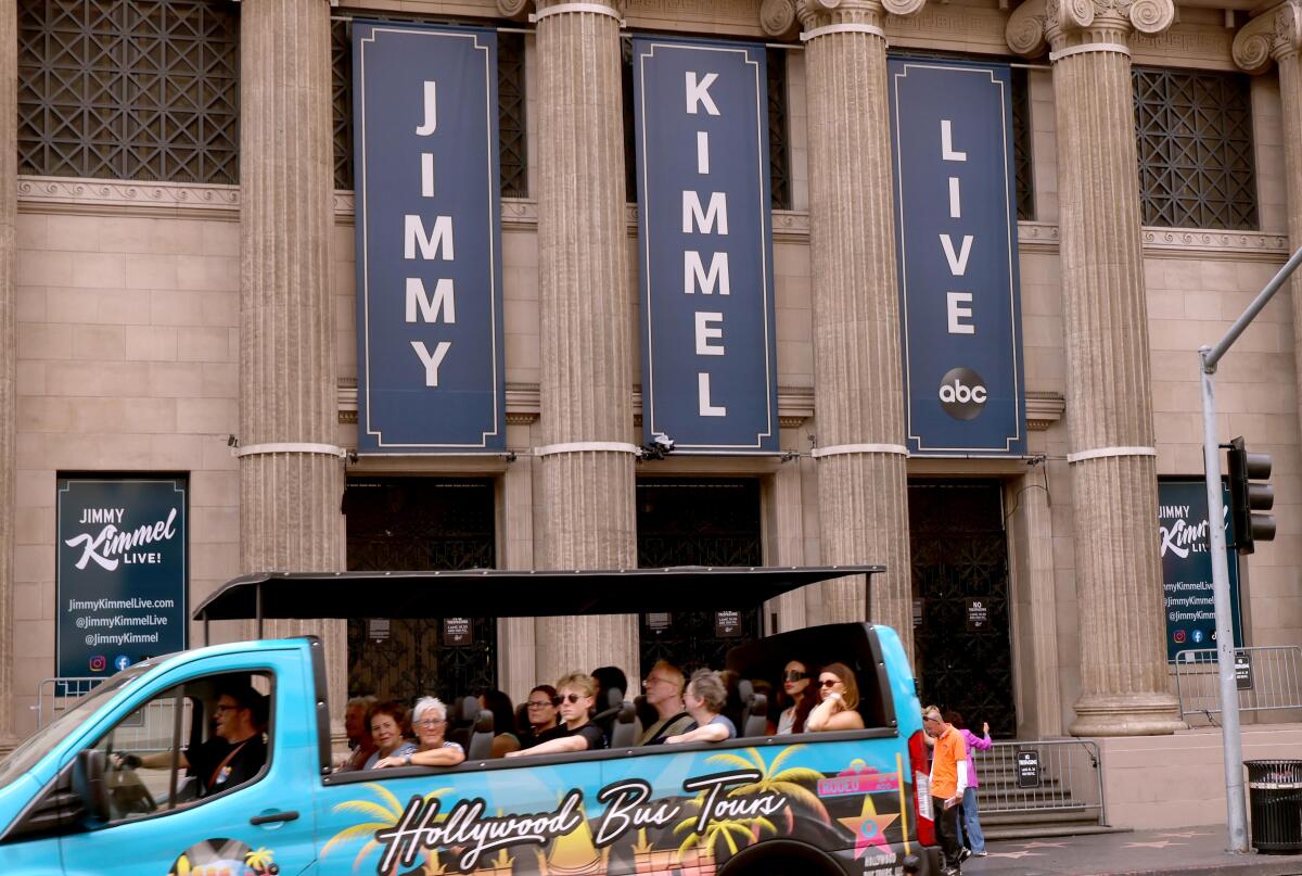 A tour bus drives past the Jimmy Kimmel Theater a day after ABC has pulled the late-night host off air.