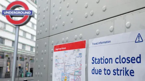 Reuters A station closed sign attached to a wall in front of an Underground station, with another sign giving details of buses from Victoria next to it