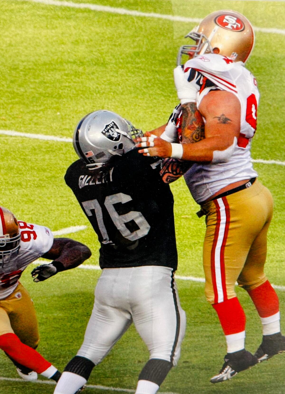 A football player lifts another football player into the air.