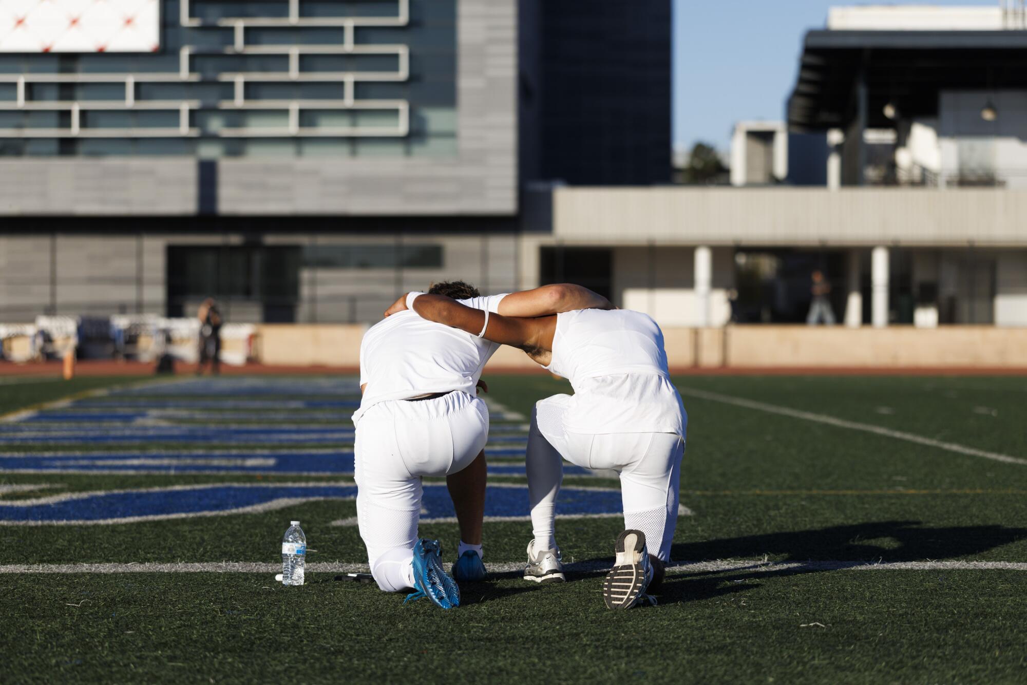 Pali High's Jack Thomas, left, and King Demethris pray before their Sept. 5 game against Granada Hills.