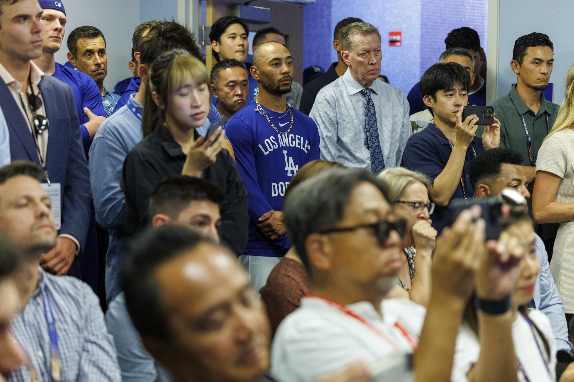 Dodgers players, including shortstop Mookie Betts and two-way star Shohei Ohtani listen to Clayton Kershaw speak.