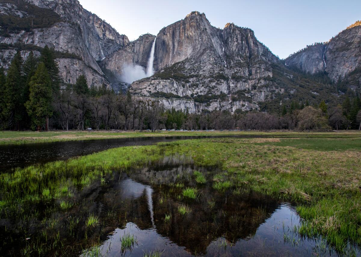 A waterfall is reflected in water in the meadow in the Yosemite Valley as the snowpack melts.