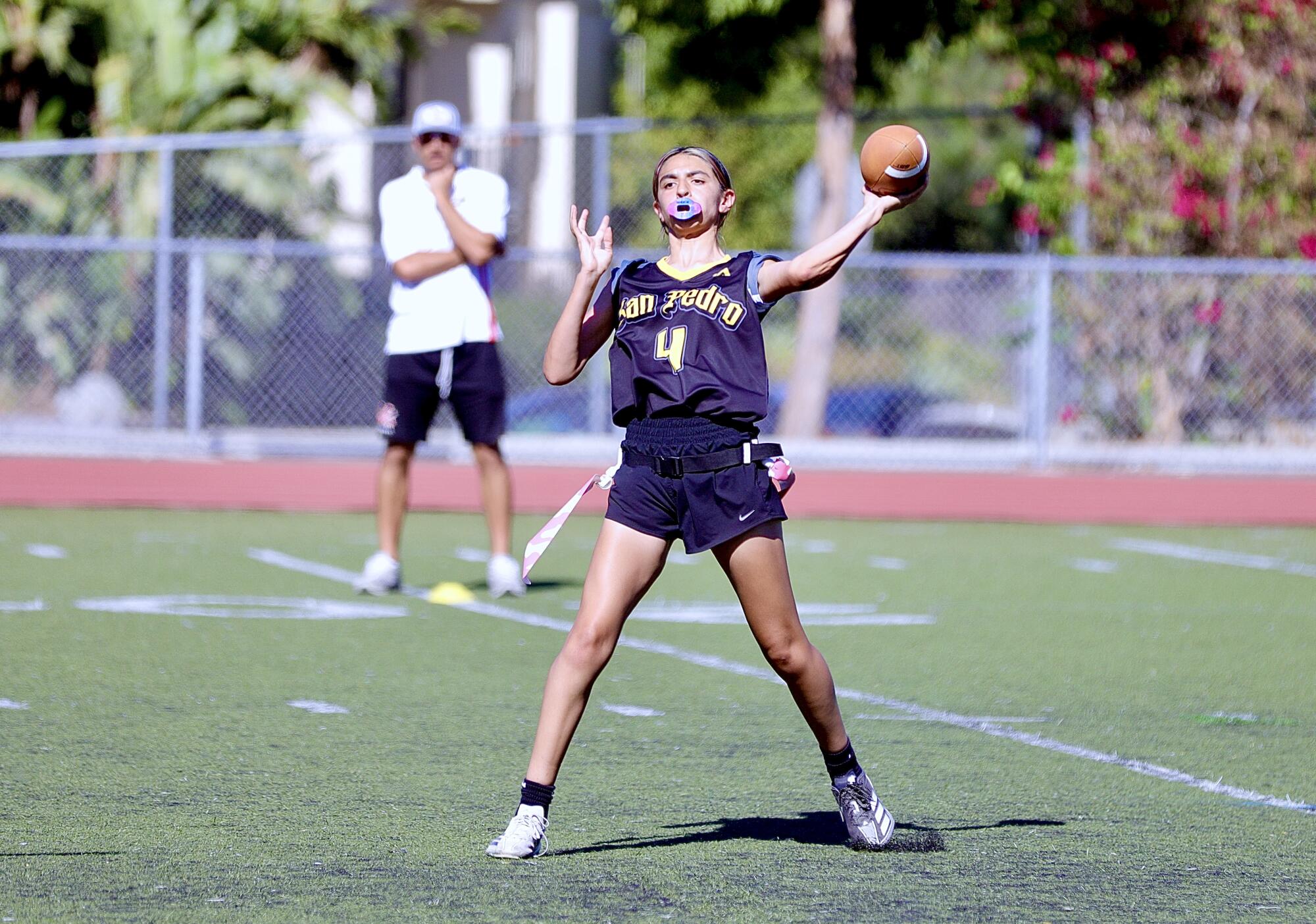 San Pedro quarterback Madison Adrid looks up field as she throws the football.