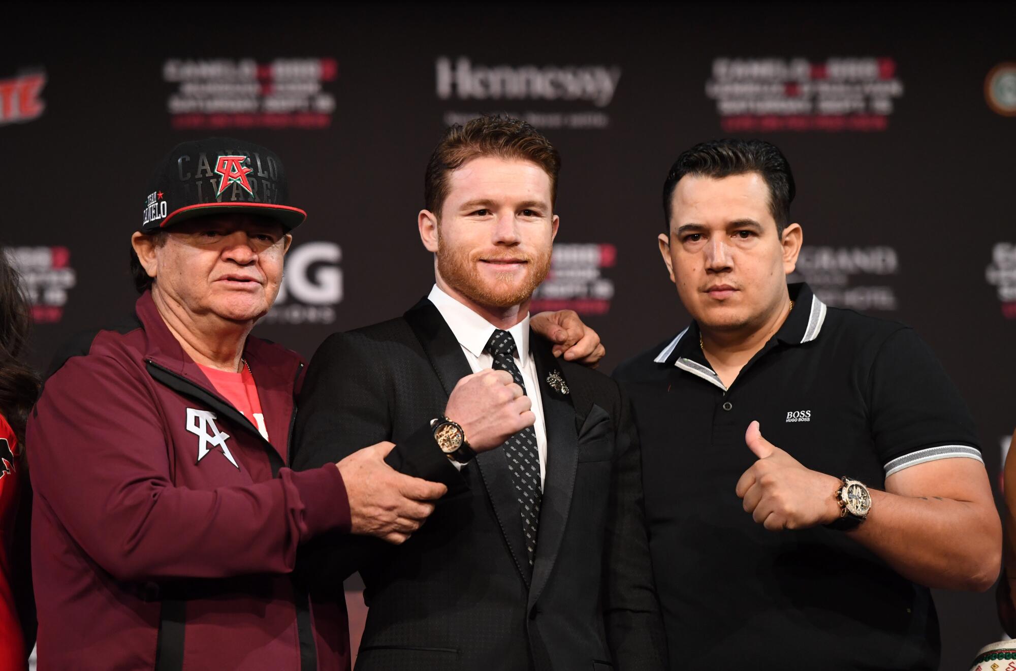 Boxer Canelo Álvarez, center, poses alongside his trainers Chepo Reynoso, left, and Eddy Reynoso, right, at MGM Grand