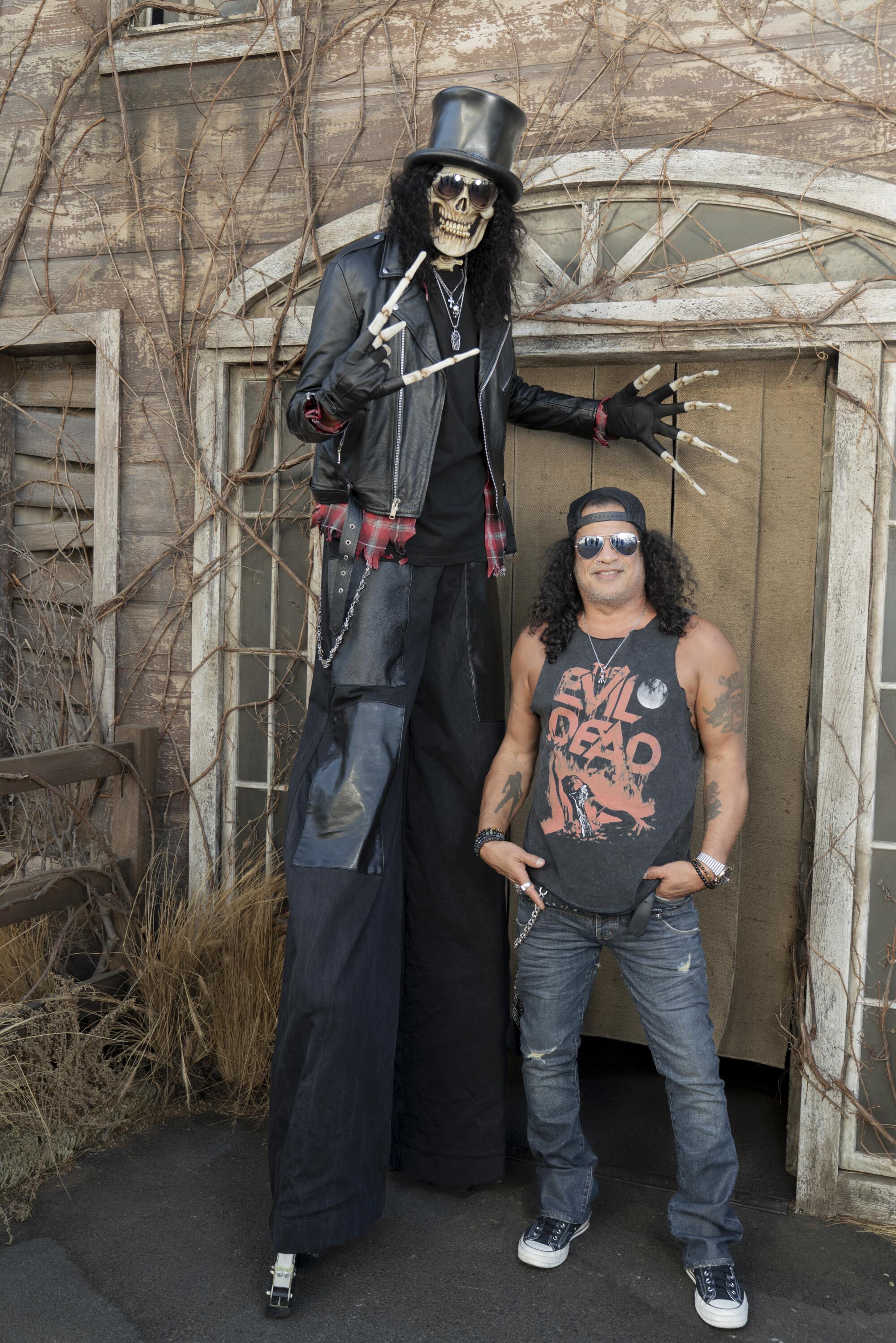 A skeletal stilt walker and guitarist Slash.