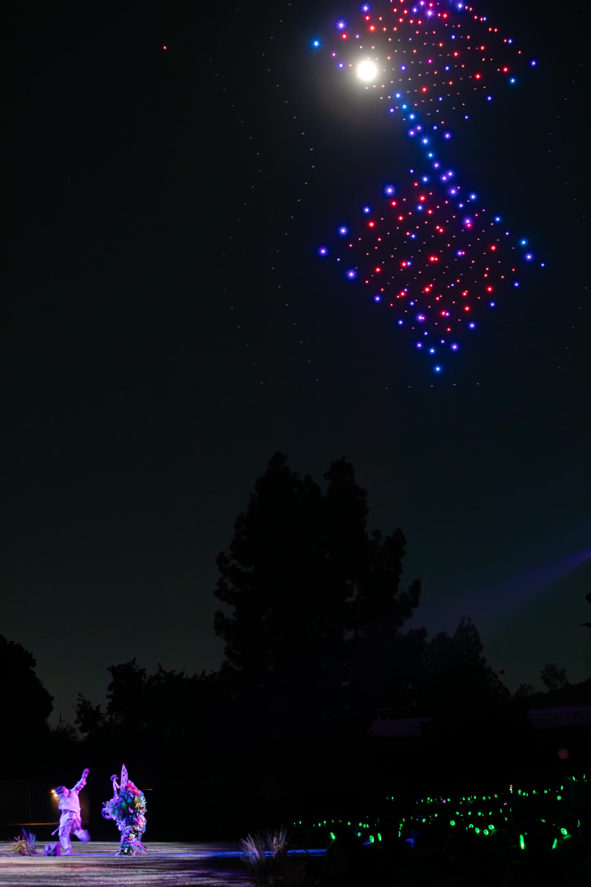 Colorful drones framed by the moon.