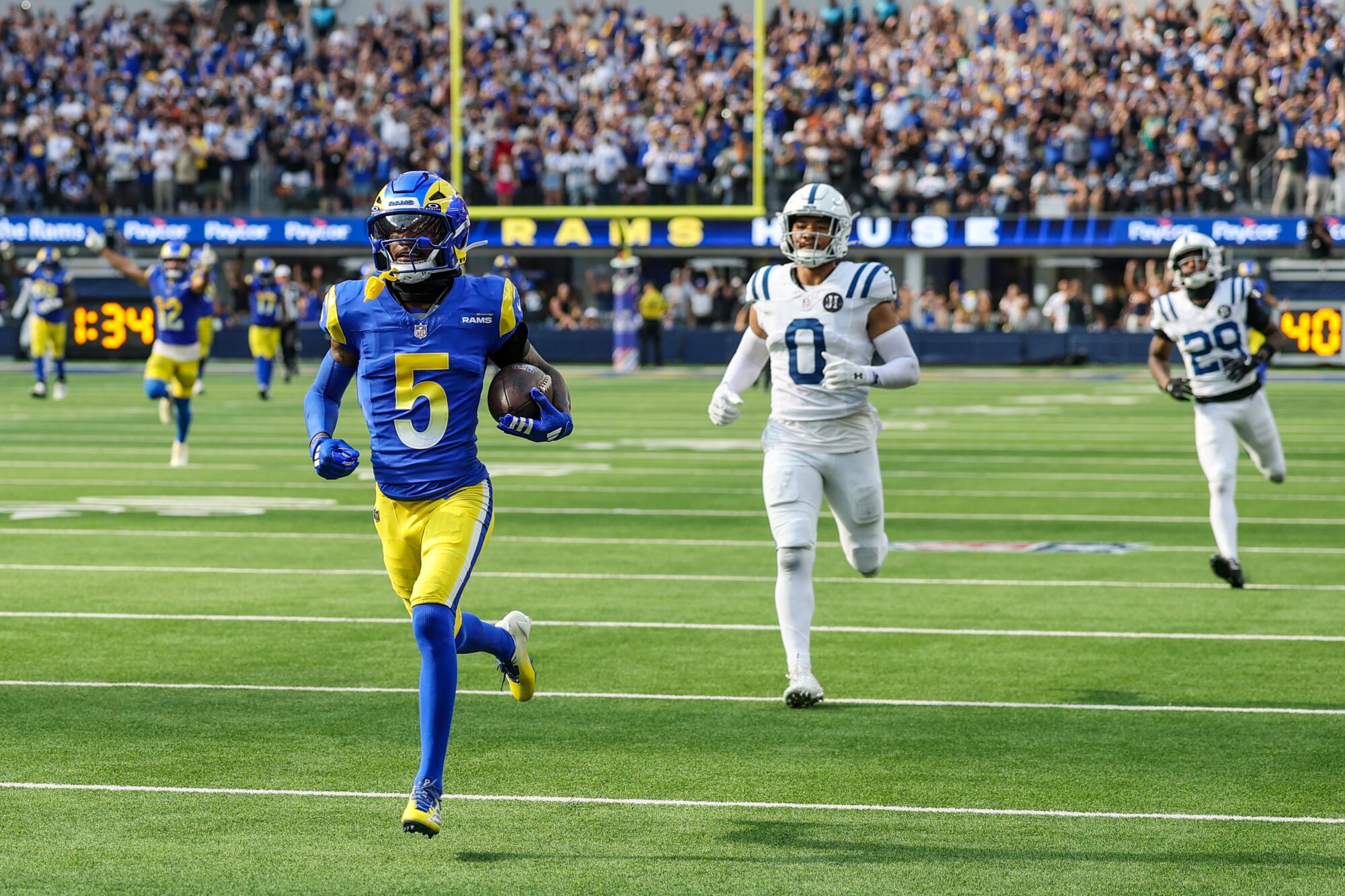 Rams wide receiver Tutu Atwell trots into the end zone ahead of Colts defensive back Camryn Bynum.