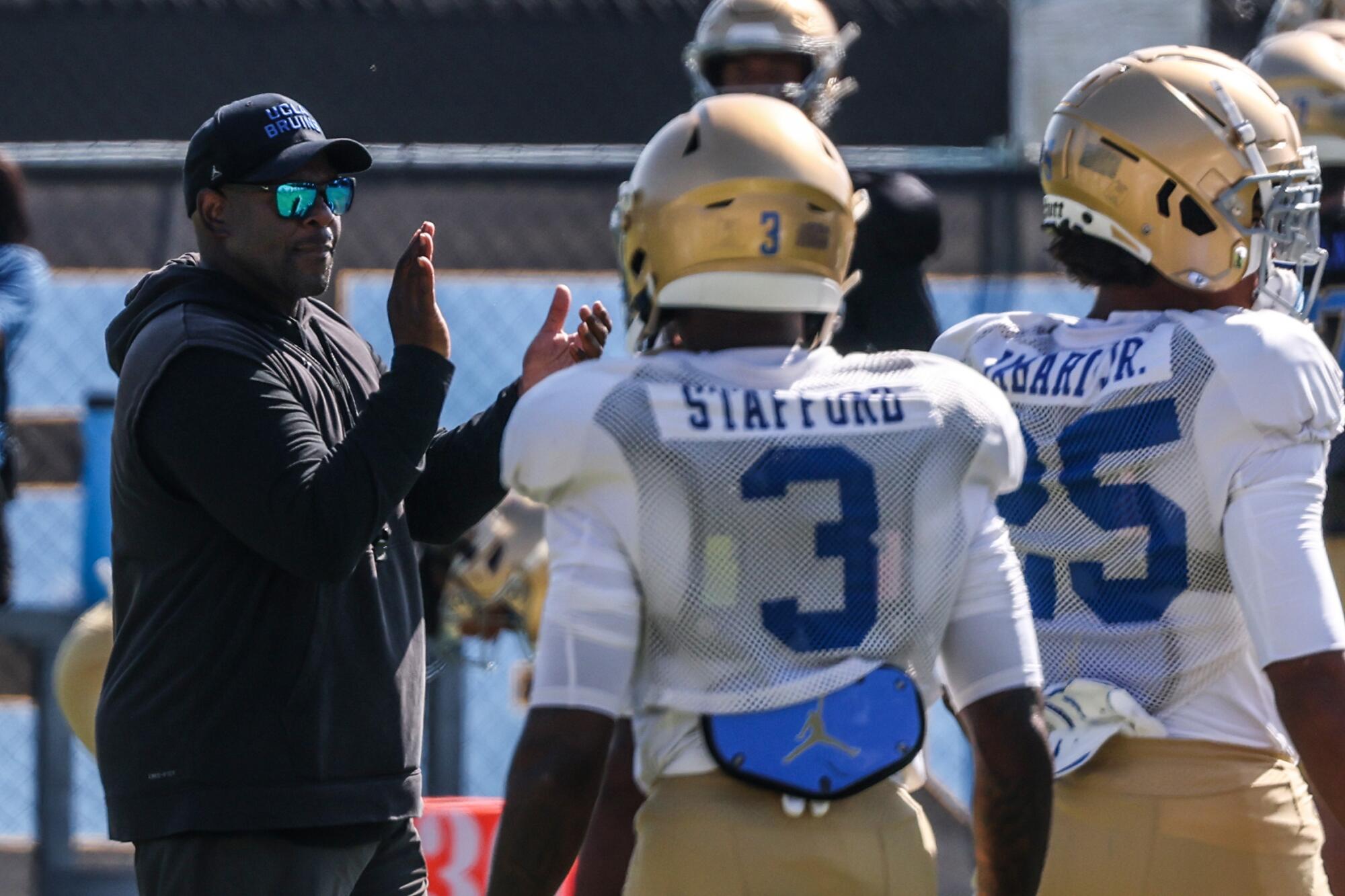 UCLA interim head football coach Tim Skipper claps as players participate in practice at Drake Stadium on Wednesday.