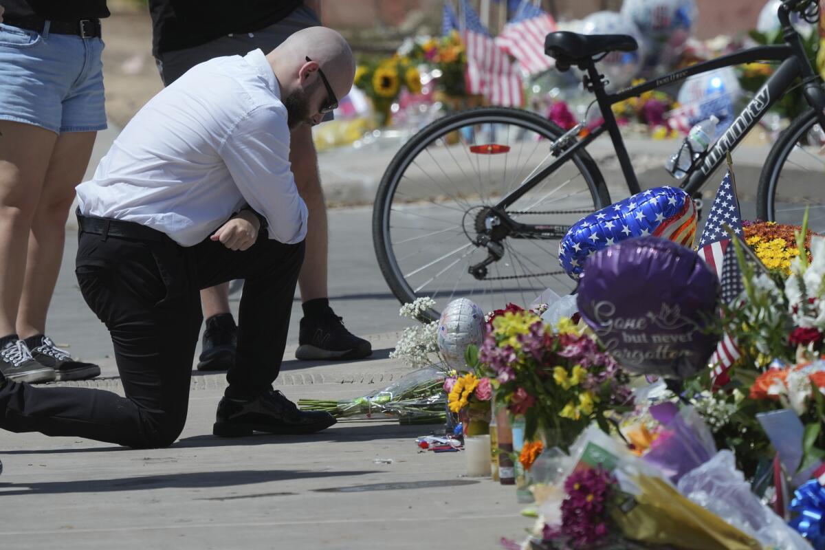 A well-wisher prays at a makeshift memorial in Phoenix after the shooting death of Charlie Kirk.